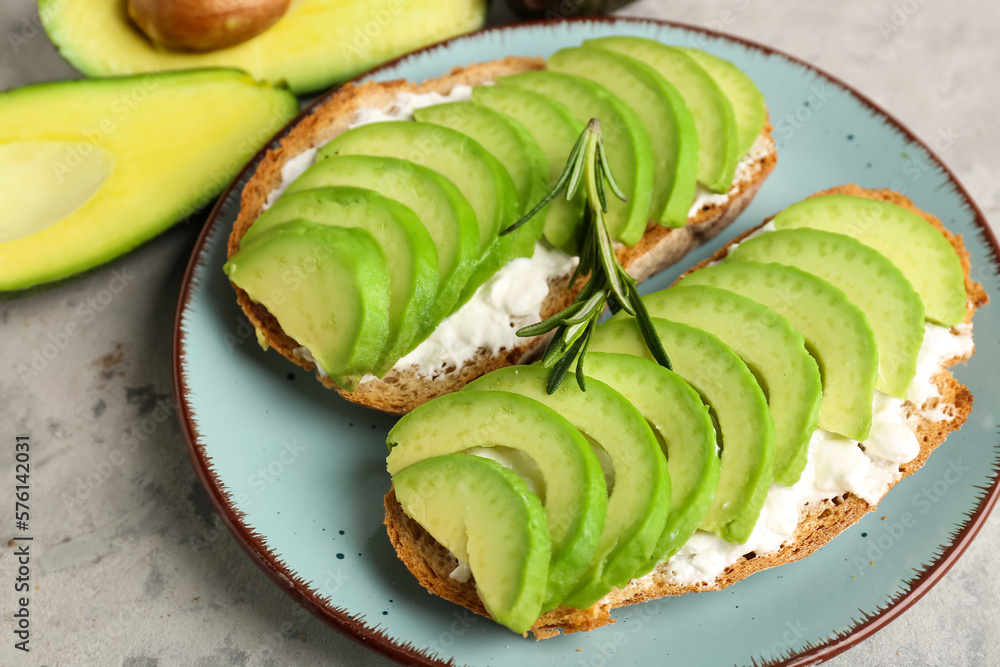 Plate with delicious avocado toasts on grey background