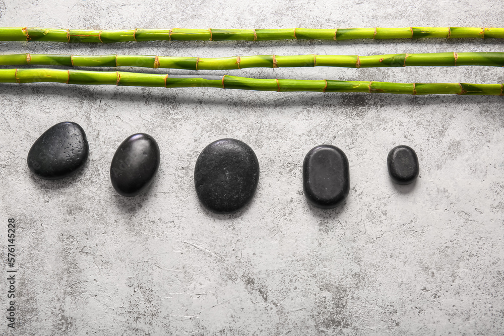 Spa stones and bamboo on light background, top view