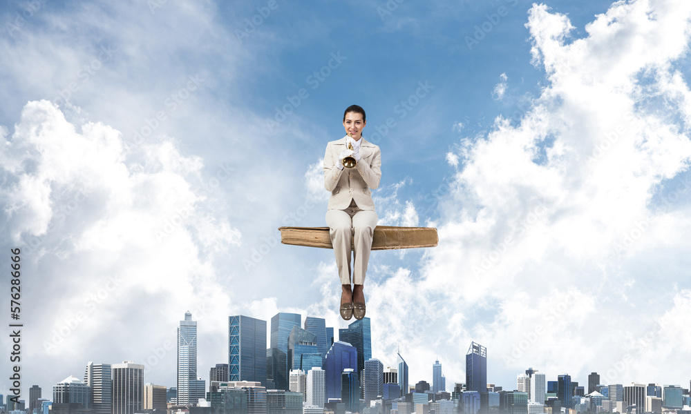 Elegant woman in business suit sitting on book