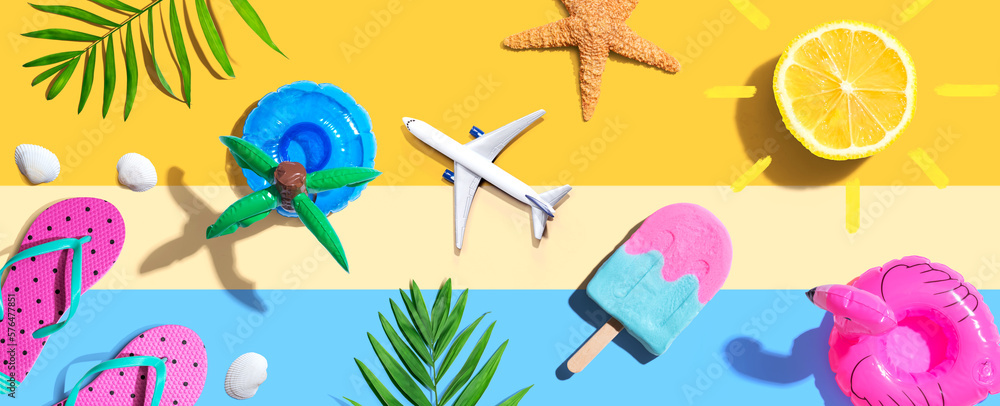 Summer concept with a airplane, a popsicle, flip flops and lemon sunshine - flat lay