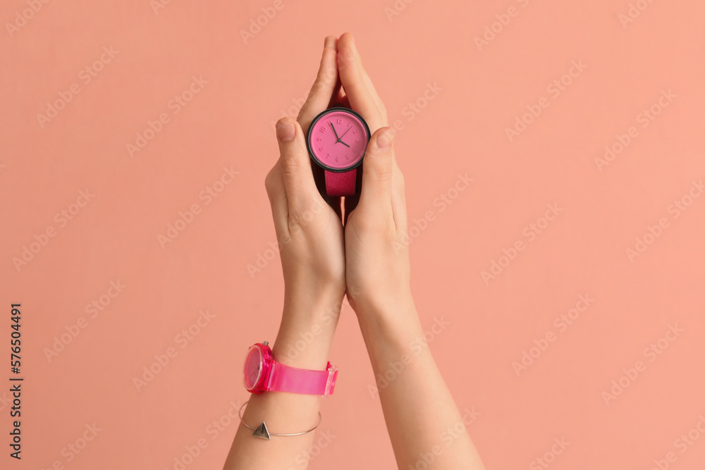 Woman with stylish wristwatches on pink background