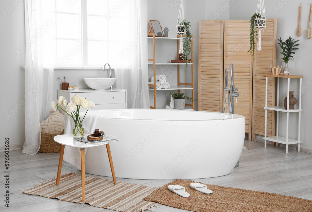 Interior of bathroom with ranunculus flowers in vase on table