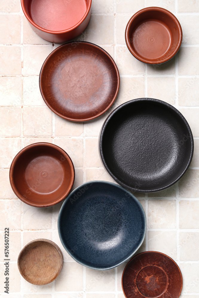 Composition with clean ceramic plates and bowls on tile background