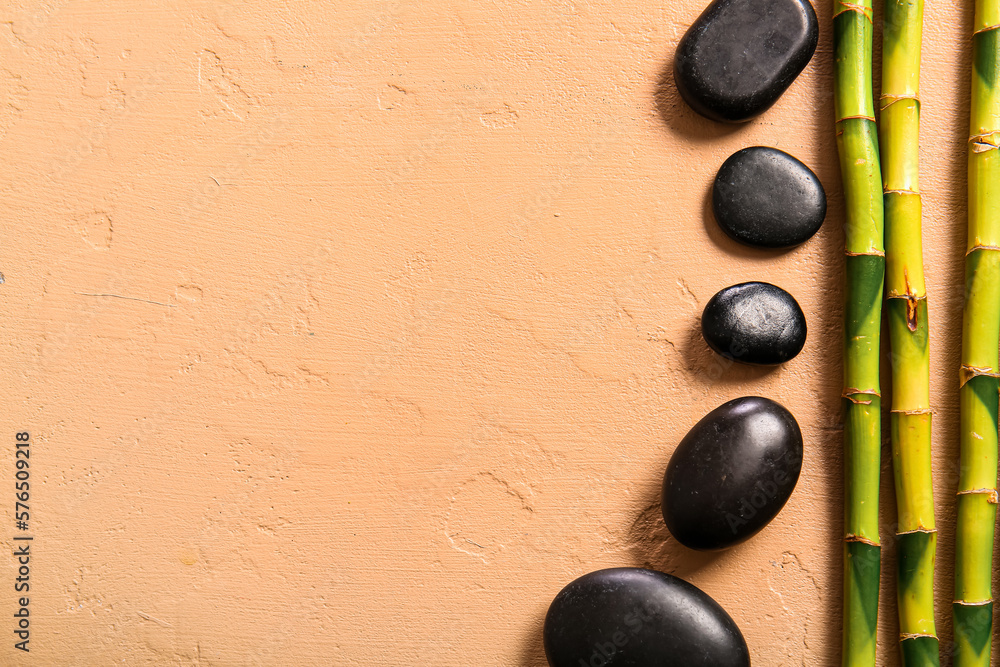 Spa stones and bamboo on beige background, top view