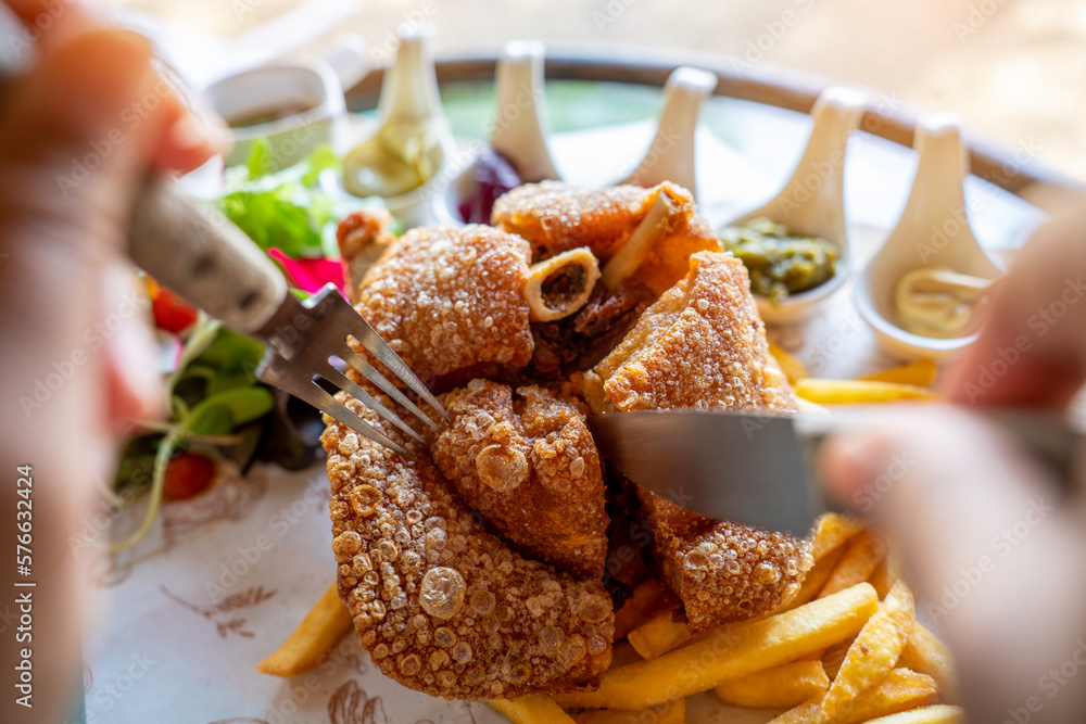 Eisbein with braised cabbage, salad and Yummy french fries with set of souces in bowl. Traditional O