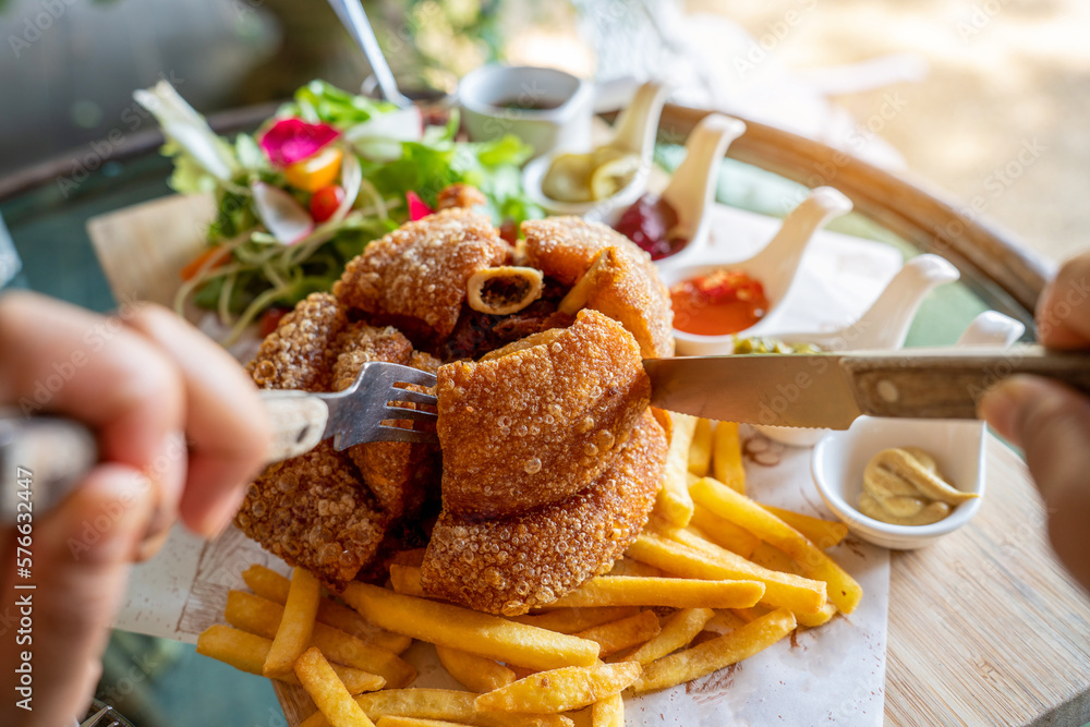 Eisbein with braised cabbage, salad and Yummy french fries with set of souces in bowl. Traditional O