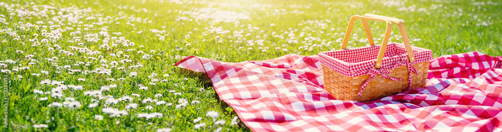 Picnic duvet with empty bascket on the meadow in nature.