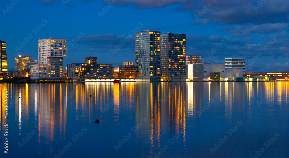 Waterfront city skyline with reflection in the lake at sunset, Almere, Flevoland, Netherlands