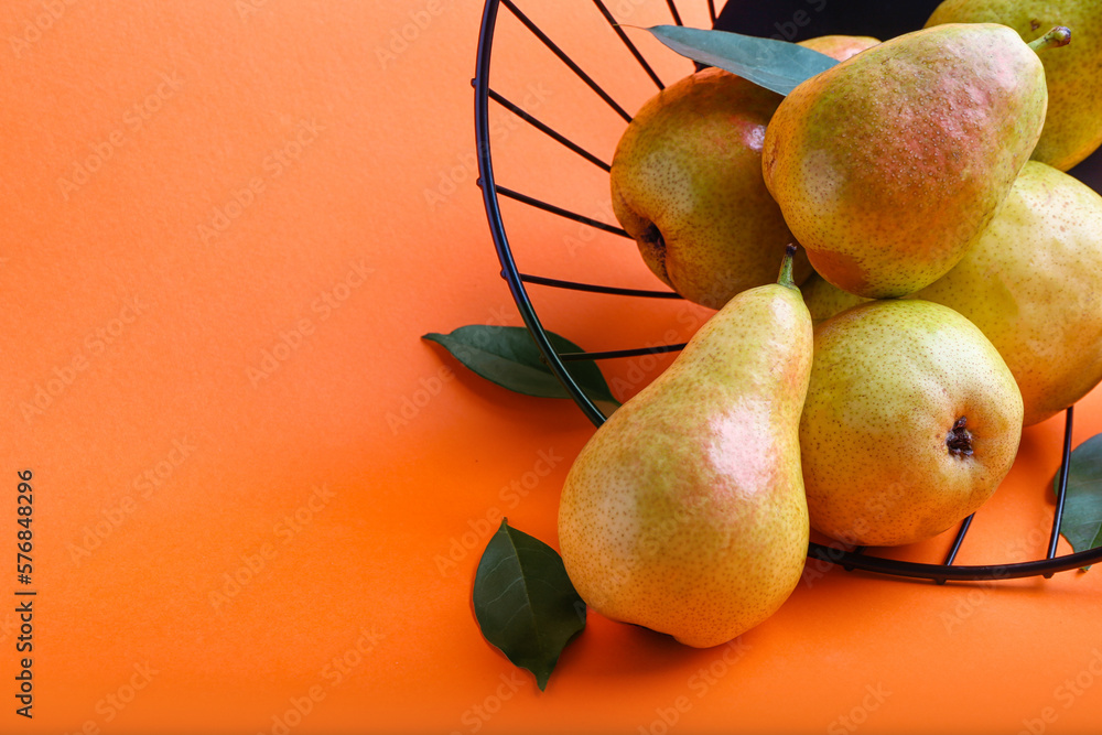 Basket with ripe pears on color background, closeup