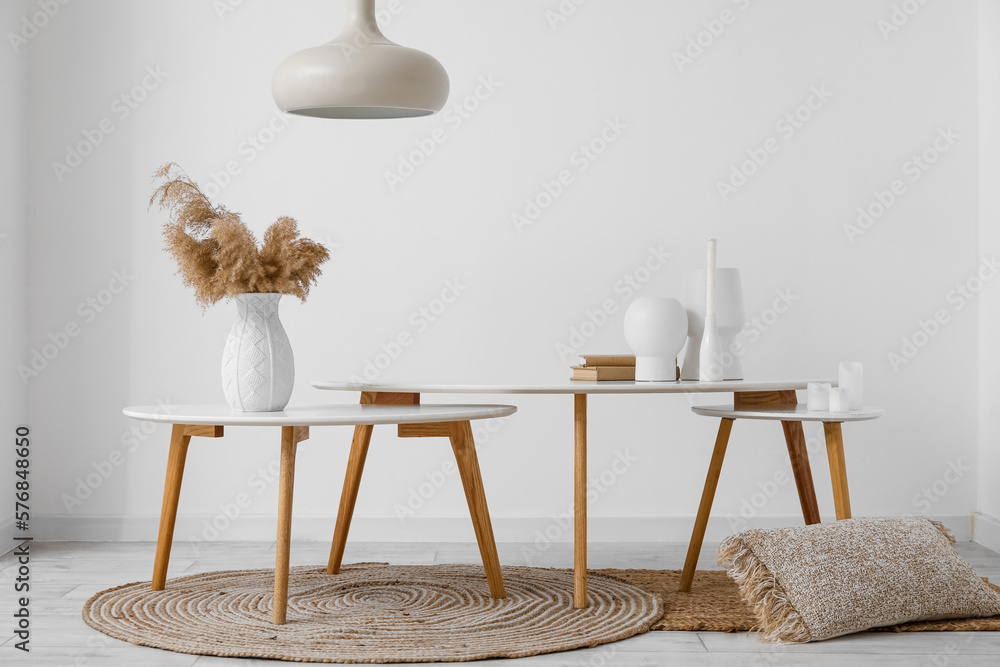 Interior of light room with tables, vases and pampas grass