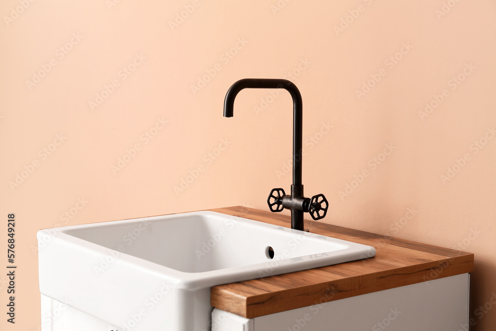 Table with ceramic sink near beige wall