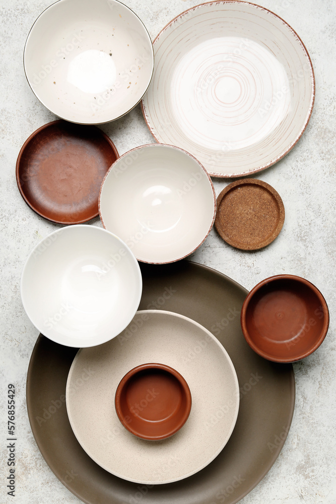 Composition with clean ceramic plates and bowls on white background