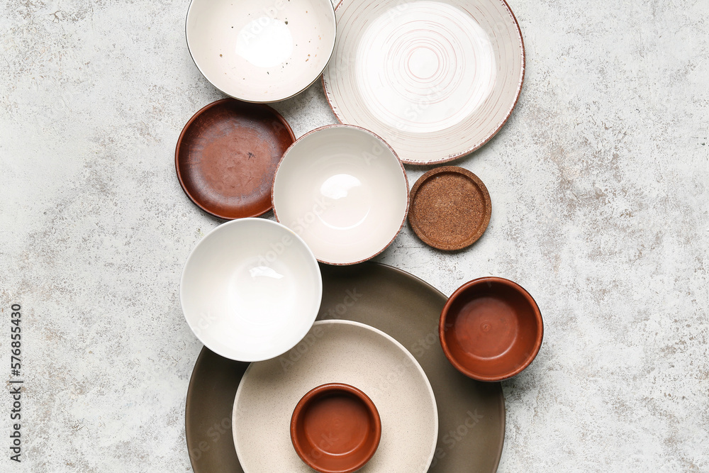 Composition with clean ceramic plates and bowls on white background