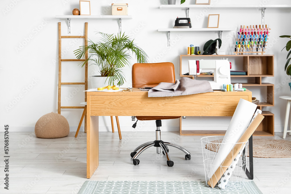 Tailors workplace with sewing machine in interior of modern atelier