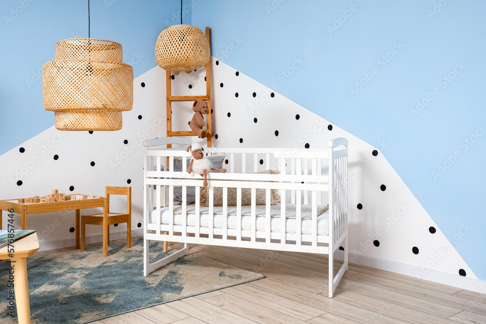 Interior of childrens bedroom with crib, table and ladder