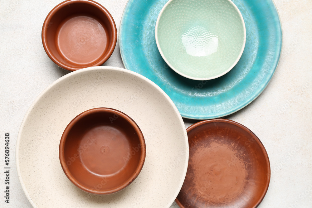 Composition with clean ceramic plates and bowls on white background