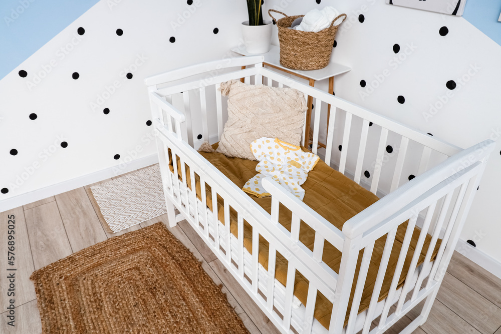 Crib with baby bodysuit in childrens bedroom