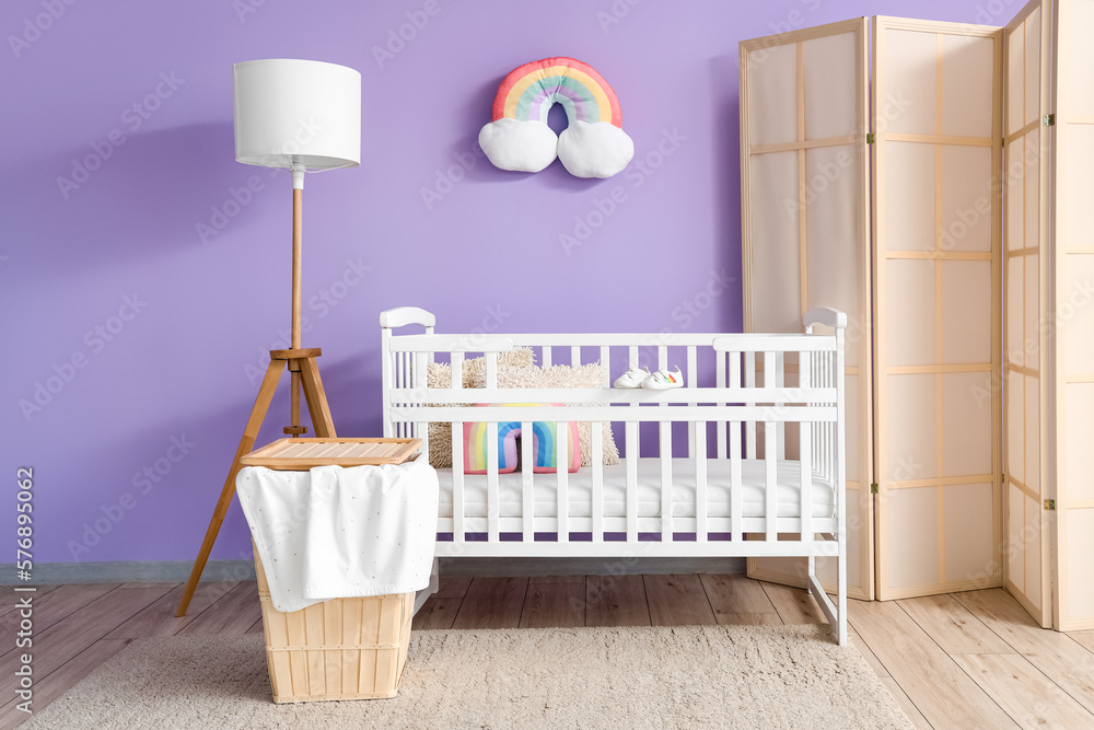 Interior of childrens bedroom with crib, basket and lamp