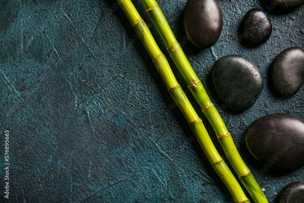 Spa stones and bamboo on dark background, top view