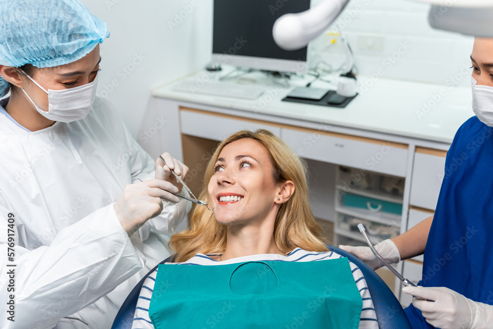 Female dentist examine tooth to Caucasian girl at dental health clinic. 