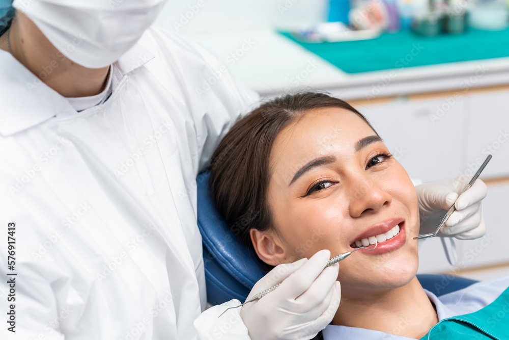 Caucasian dentist examine tooth for young girl at dental health clinic. 