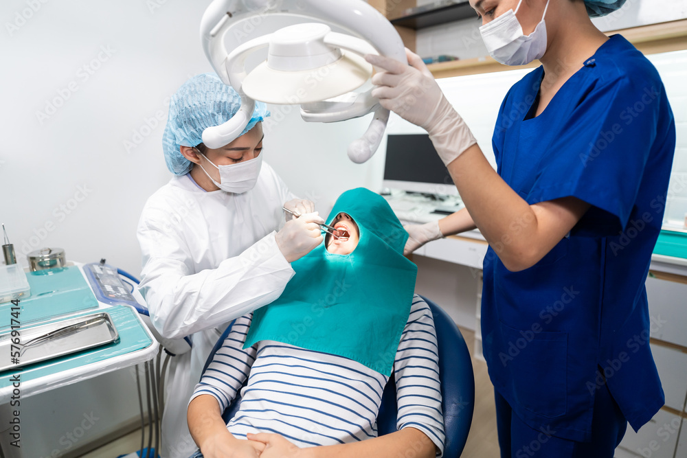 Female dentist examine tooth to Caucasian girl at dental health clinic. 