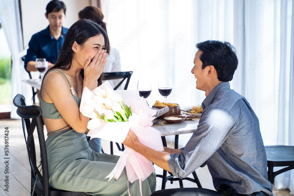 Asian romantic man making surprise proposal of marriage to girlfriend. 