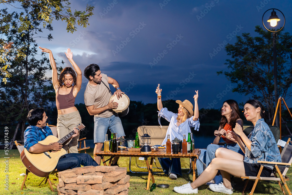 Group of diverse friend having outdoors camping party together in tent. 