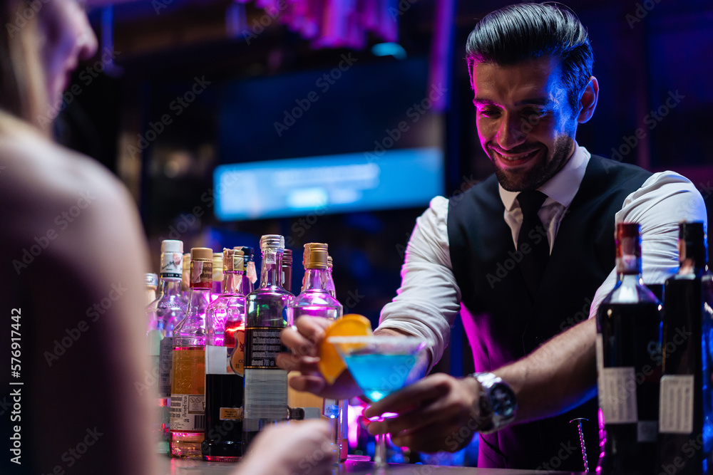 Caucasian profession bartender making a cocktail for women at a bar. 