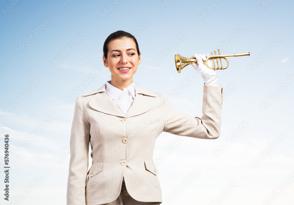 Beautiful woman holding trumpet brass near ear