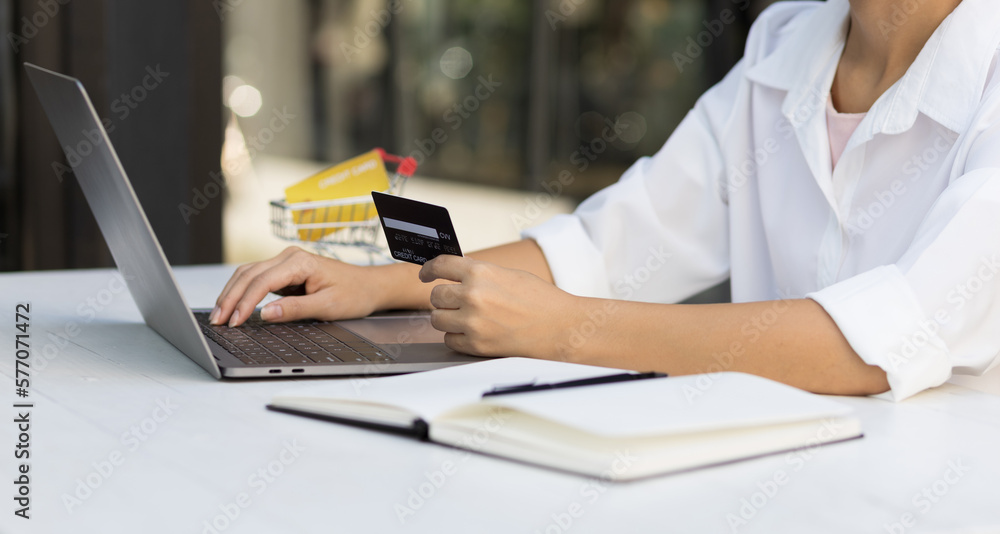 Woman holding credit card and using laptop. Online payment and online  shopping concept.