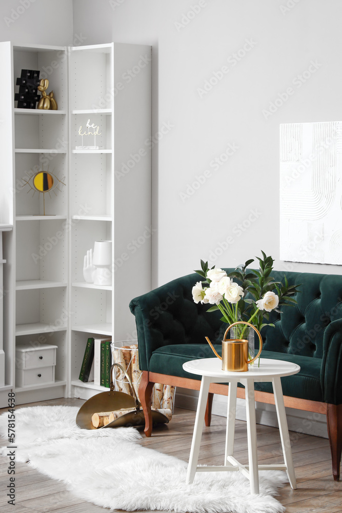 Interior of living room with flowers in vase and sofa