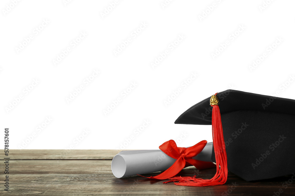 Graduation hat with diploma on table against white background