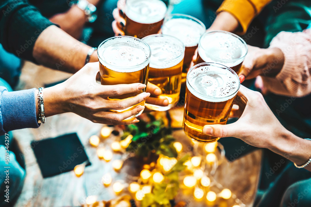 Group of people drinking beer at brewery pub restaurant - Happy friends enjoying happy hour sitting 