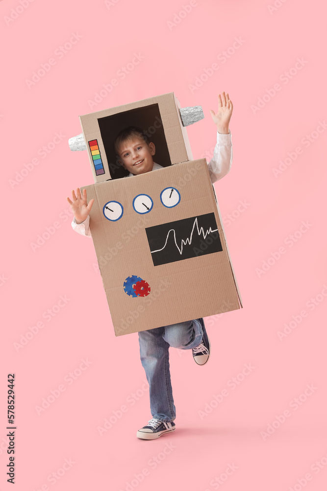 Little boy in cardboard robot costume on pink background