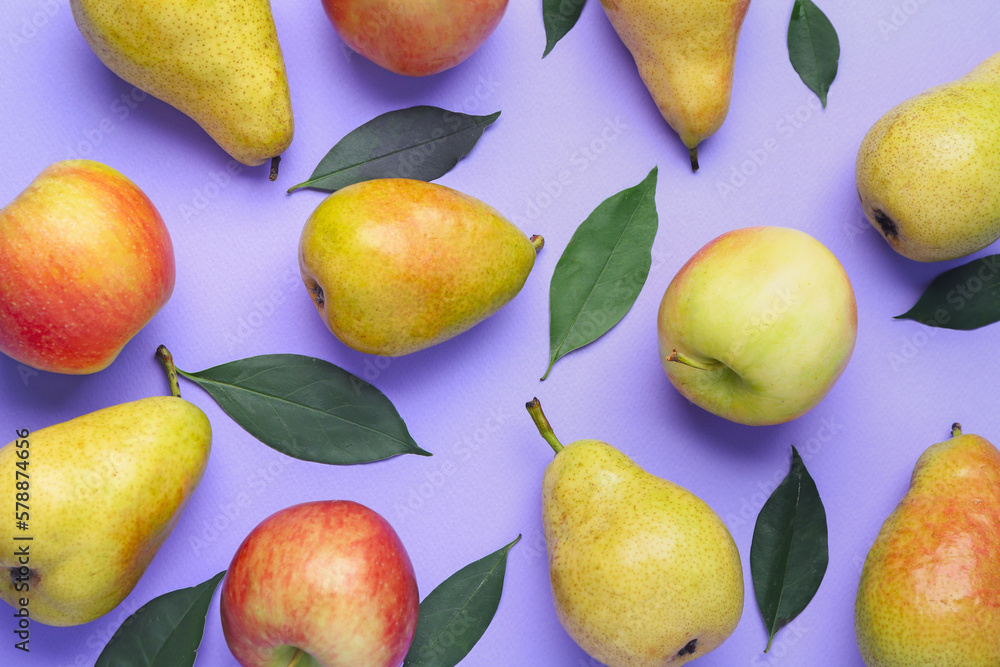 Fresh pears, apples and green leaves on lilac background