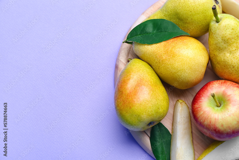 Wooden board with fresh pears on lilac background, closeup