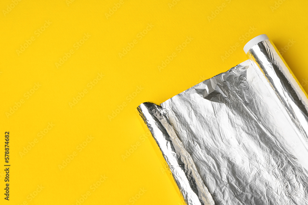 Aluminium foil roll on yellow background