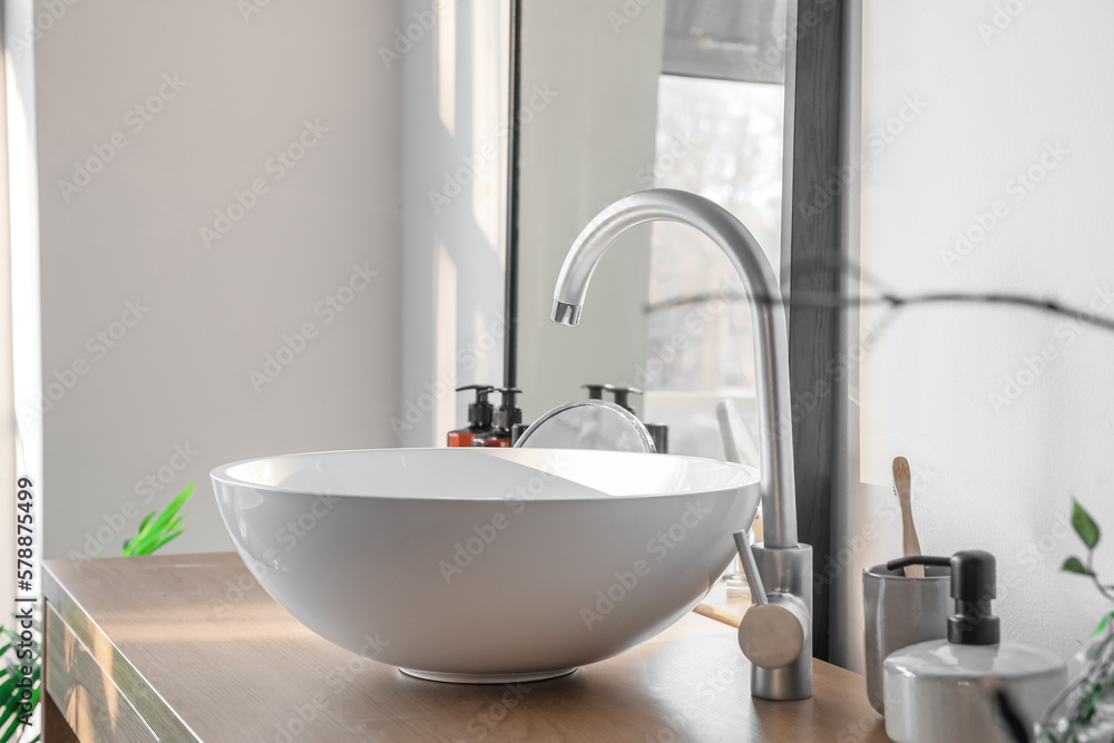 White sink on table in light bathroom, closeup