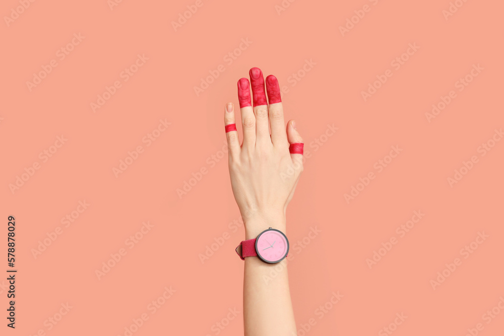 Woman with painted fingers and stylish wristwatch on pink background