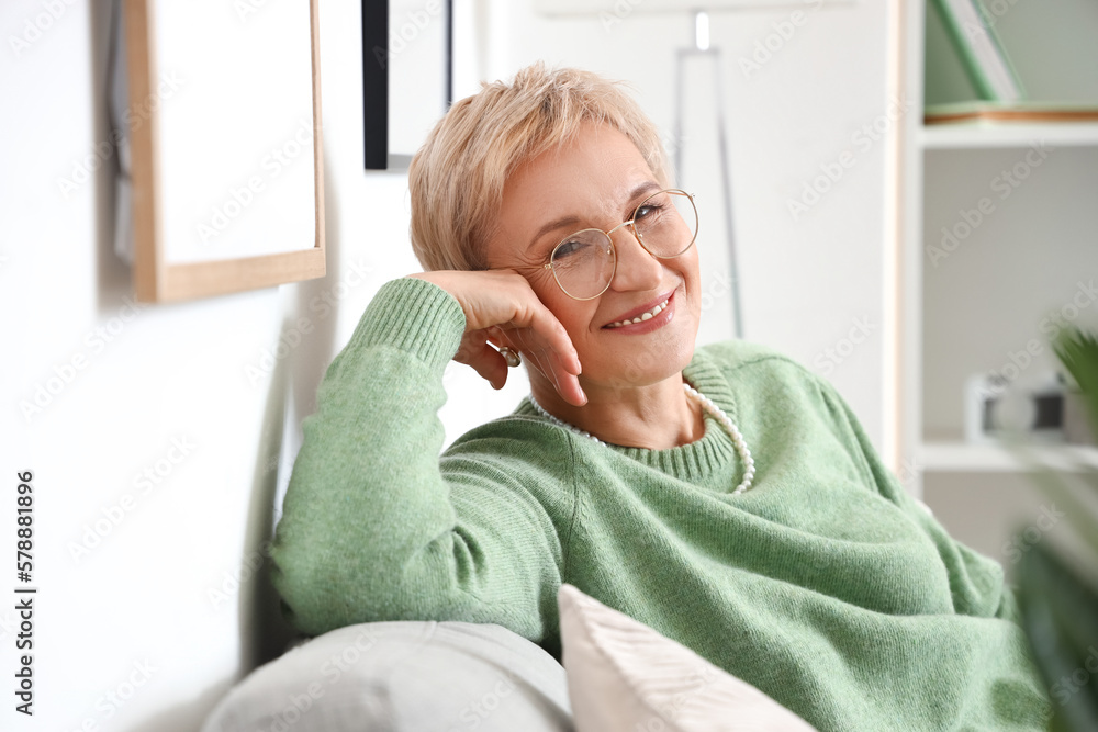 Mature woman sitting on sofa at home, closeup