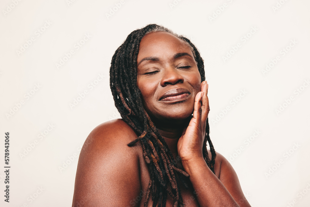 Beautiful black woman touching her flawless skin