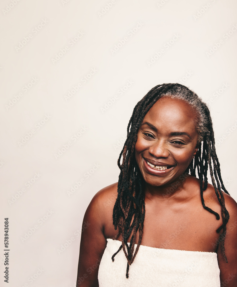 Mature woman smiling happily in a bath towel