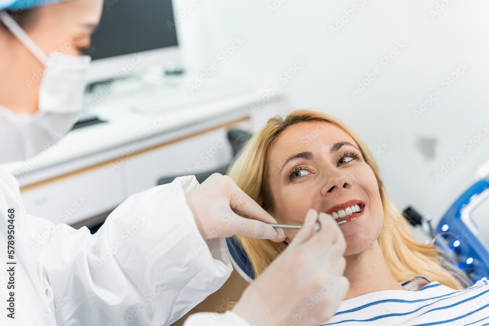 Female dentist examine tooth to Caucasian girl at dental health clinic. 