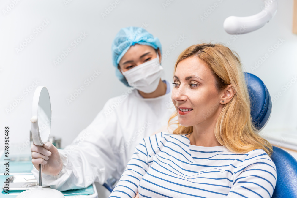 Female dentist examine tooth to Caucasian girl at dental health clinic. 