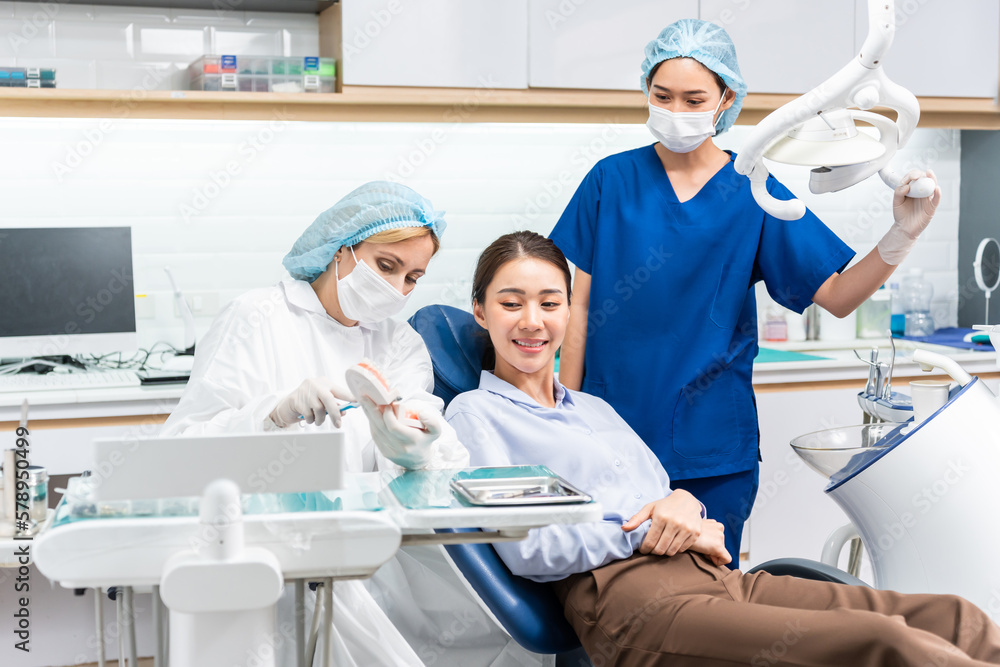 Caucasian dentist examine tooth for young girl at dental health clinic. 