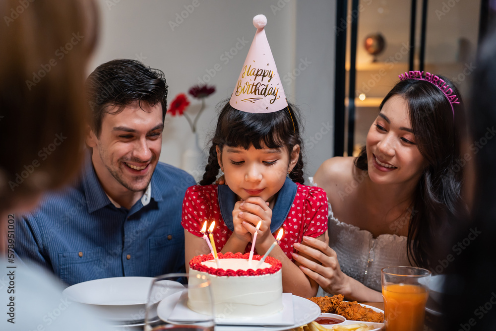 Multi-ethnic big family having a birthday party for young kid daughter. 