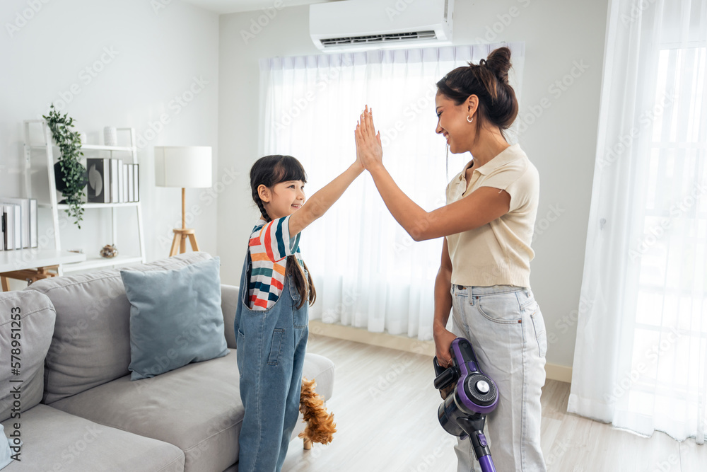 Caucasian beautiful mother cleaning house with young kid daughter. 