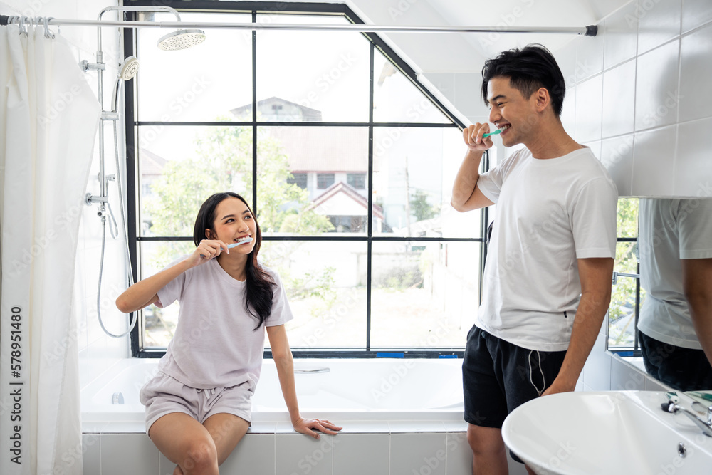 Asian new marriage couple brushing teeth together in bathroom at home. 