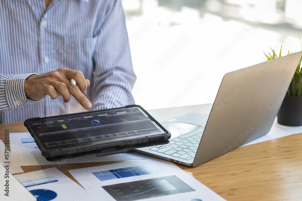 Businessman working on tablet analysis stock market investment graph. Investors analyzing stock mark